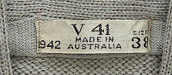Label located on the inside collar of the Australian made V‐neck sweater shown above. The letter V indicates the sweater was made in the state of Victoria. Australian made clothing usually had labels that displayed a code consisting of a letter followed by numbers where the letter stood for the state where the garment was manufactured, and the numbers represented a specific manufacturer. Also included was the contract year, size, and Made in Australia. Label located on the inside collar of the Australian made V‐neck sweater shown above. The letter V indicates the sweater was made in the state of Victoria. Australian made clothing usually had labels that displayed a code consisting of a letter followed by numbers where the letter stood for the state where the garment was manufactured, and the numbers represented a specific manufacturer. Also included was the contract year, size, and Made in Australia.