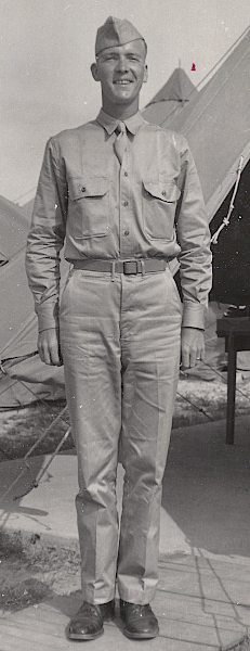 Pvt. Hogan wears the summer service uniform featuring the khaki cotton field cap and necktie. The shirt is specification QMC 6‐241 with standing and falling collar and front button placket. Below the belt on his right side is a watch pocket with double welt construction indicating his trousers are specification QMC 6‐254. Note the olive‐drab web belt with frame buckle. Pvt. Hogan wears the summer service uniform featuring the khaki cotton field cap and necktie. The shirt is specification QMC 6‐241 with standing and falling collar and front button placket. Below the belt on his right side is a watch pocket with double welt construction indicating his trousers are specification QMC 6‐254. Note the olive‐drab web belt with frame buckle.