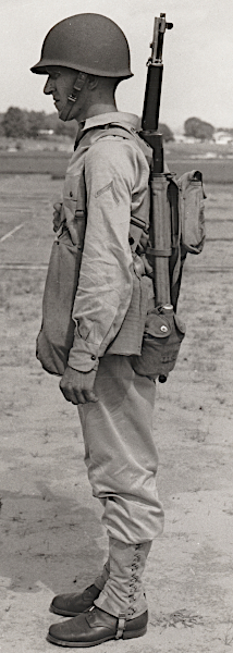 U.S. Army photograph published 13 August 1941 showing the khaki cotton field uniform outfitted for the combat role. The soldier dons the new M‐1 steel helmet, leggings, gas mask carrier, and full field pack. By mid‐1942, the khaki cotton uniform would be supplanted by the two‐piece herringbone twill uniform for use as a hot weather combat uniform. U.S. Army photograph published 13 August 1941 showing the khaki cotton field uniform outfitted for the combat role. The soldier dons the new M‐1 steel helmet, leggings, gas mask carrier, and full field pack. By mid‐1942, the khaki cotton uniform would be supplanted by the two‐piece herringbone twill uniform for use as a hot weather combat uniform.
