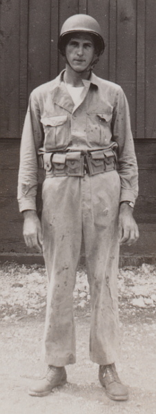 The two‐piece herringbone twill work uniform was worn for field training exercises and was later adopted as a summer combat uniform.  In this 1942 photo, Private John Sabon wears the herringbone twill uniform with the jacket tucked inside the trousers.  Underneath the jacket he wears a white sleeveless undershirt.  He also wears a cartridge belt and complete M-1 helmet consisting of steel shell and liner.  Note the abundant paint splatter on his uniform indicating that it has been used for chore work.