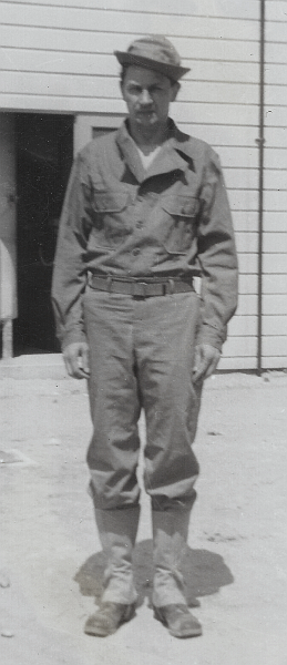 This soldier wears the two‐piece herringbone twill work suit complete with hat and canvas leggings.  The jacket is being worn tucked inside the trousers clearly exposing the M‐1937 web belt.  Note the hat canted on the head with the brim turned up.  The creative ways in which the hat was worn was a source of irritation for Army brass and likely contributed to its replacement with a cap in mid‐1942.