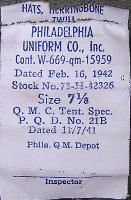 This label shows the revised specification number and date for the herringbone twill hat. Procurement of the hat ended in May 1942, after which it became a limited standard item to be issued until stocks were exhausted.  The herringbone twill hat was replaced by a cap of the same material.  Large procurements of the hat meant that it would continue to be issued for some time after the appearance of the cap.