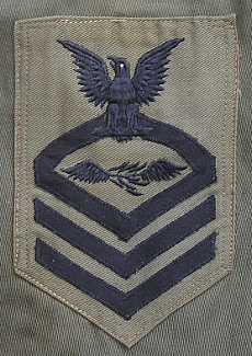 Chief Petty Officer's rating badge with Aviation Radio Technician specialty mark in center.