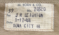 Tailor's label showing a date of 17 January 1944 for the flat pocket khaki coat pictured to the left.