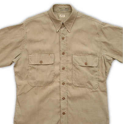 Close-up of US Navy khaki shirt made in cotton poplin.  Note the stand-up collar and front button placket.   Khaki shirts in a number of different styles and fabrics were worn during the WW2 era.  Shirts were made in either cotton twill or poplin fabrics, convertible or stand-up collars, as well as a number of different pocket flap designs.