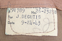Tailor's label showing a date of 24 September 1943 for the tropical wool coat pictured to the left. 